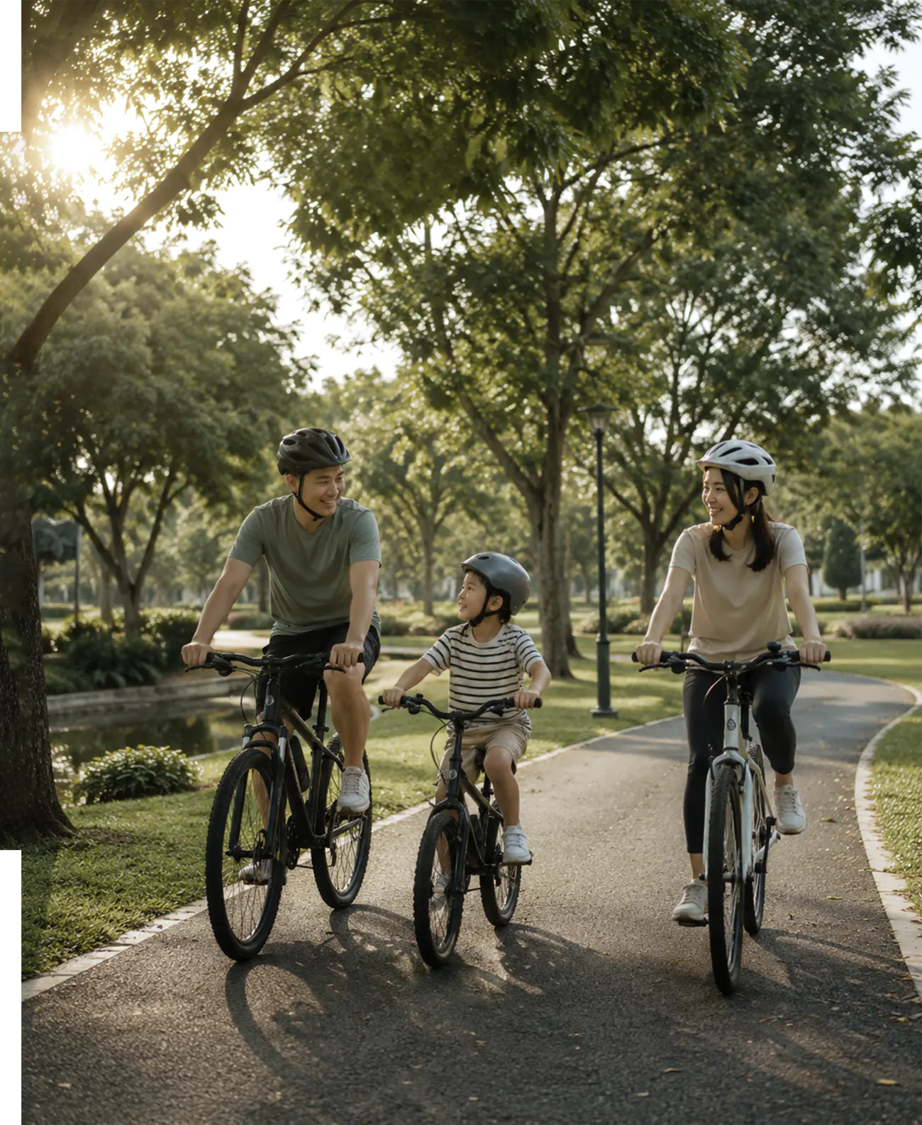 Family cycling together along a tree-lined park path
